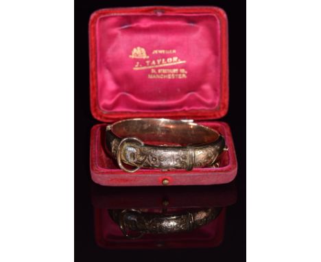 A 9ct gold buckle bangle with engraved decoration, 21.2g, 4.7 x 5.8cm, in original box