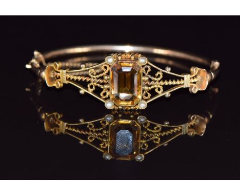 A 9ct gold bangle set with an emerald cut citrine and seed pearls, 7.8g, 4.8 x 5.5cm