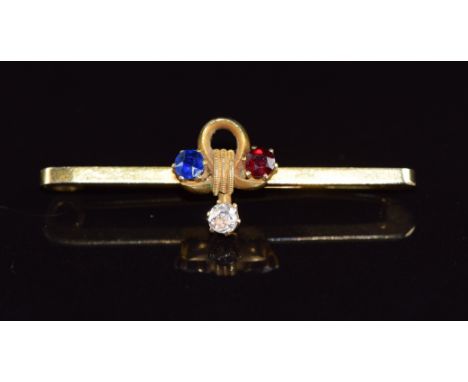 A 9ct gold brooch set with a diamond, ruby and sapphire in a clover shaped design, 2.5g, 3.5cm long