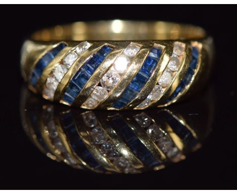 An 18ct gold ring set with square cut sapphires and round cut diamonds, 3.9g, size M