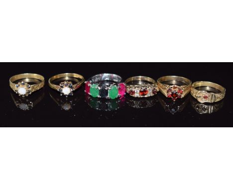 Six silver rings including opal and sapphire set, buckle ring, garnet and sapphire, emerald and ruby set