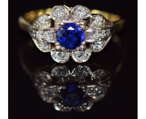 An 18ct gold ring set with a round cut sapphire of approximately 0.5ct and diamonds in a platinum setting, 4.8g, size Q