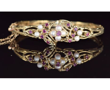 A 9ct gold bangle set with rubies and cultured pearls in a floral cluster, 16.5g, 4.7 x 5.7cm&nbsp;