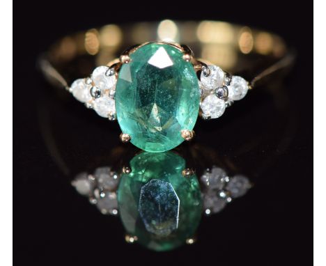 A 14k gold ring set with an oval cut emerald of approximately 1.2ct and diamonds, 1.6g, size N