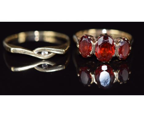 A 9ct gold ring set with three garnets (3.3g, size K/L) and a 14k gold ring set with a diamond, 1.4g, size R