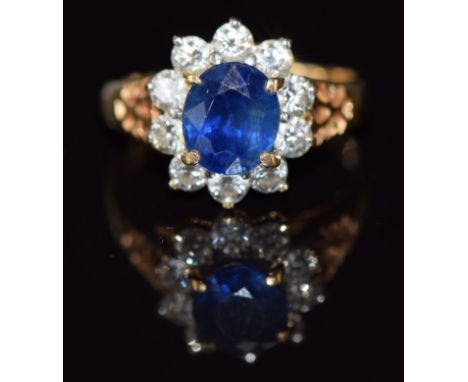 An 18ct gold ring set with a sapphire of approximately 0.8ct surrounded by diamonds, 3.3g, size J