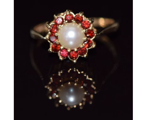 A 9ct gold ring set with a pearl surrounded by garnets, 2.5g, size O