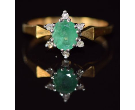 An 18ct gold ring set with an oval cut emerald and diamonds, 3.3g, size N/O&nbsp;