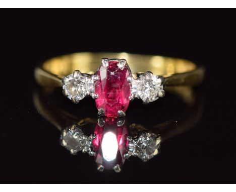 An 18ct gold ring set with an oval cut ruby and diamonds, 2.3g, size L