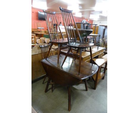 An Ercol dark elm drop-leaf table and three chairs 