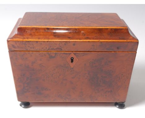 A late George III burr-yew wood and boxwood strung tea caddy of sarcophagus form,  the hinged lid revealing a foil lined twin