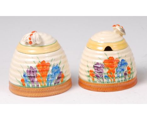 Two Clarice Cliff Crocus pattern pottery honey pots and covers, each cover with bee form finial and of domed ribbed form, eac