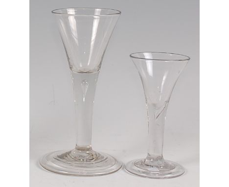 An 18th century pedestal wine glass, with drawn trumpet bowl and teardrop stem to a flaring conical foot, h.16.5cm; and one o