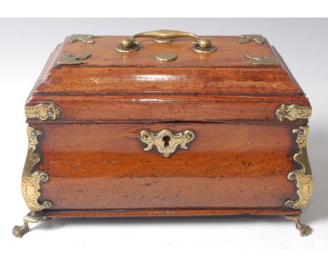 An early 19th century walnut tea caddy of bombe form, having a brass swan neck handle and further brass mounts, raised on paw