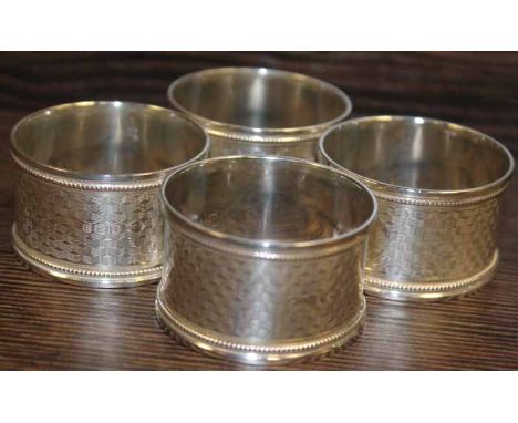 SET OF FOUR SILVER NAPKIN RINGS
with machine turned design and central blank cartouche, Birmingham marks, approximately 64g i