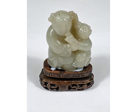 A Chinese jade coloured hardstone figure of adult and child on hard wood stand, ht. 5cm 