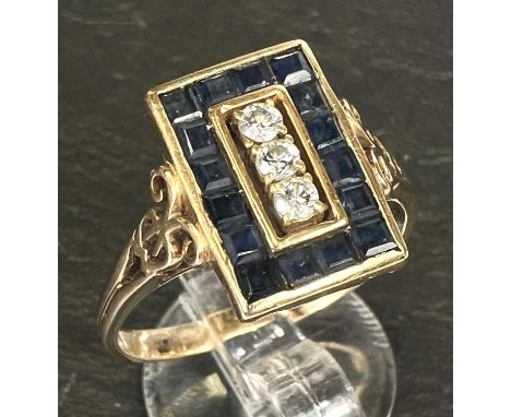 An Art Deco dress ring set 3 diamonds and pave set border of square sapphires, 18 carat gold shank 