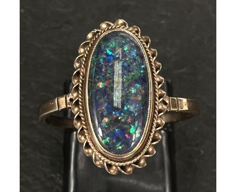 A 9 carat gold dress ring set black opal effect cabochon with rope twist border, size T