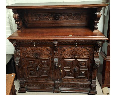 A Victorian Gothic extensively carved oak buffet sideboard with shell icons, head and paws carving with raised shelf back wit