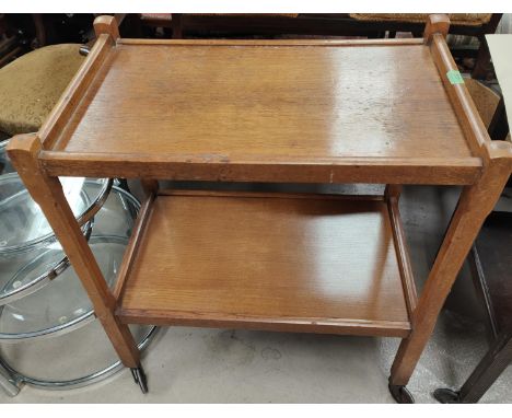A golden oak two tier drinks trolley; a wrought metal standard lamp and a chest 