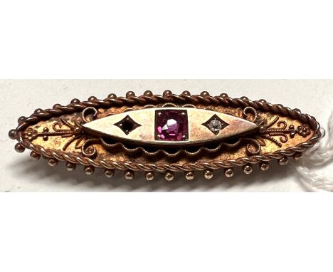 An Edwardian yellow metal bar brooch, boat shaped with beaded filigree decoration, set central ruby and 2 diamond chips, stam