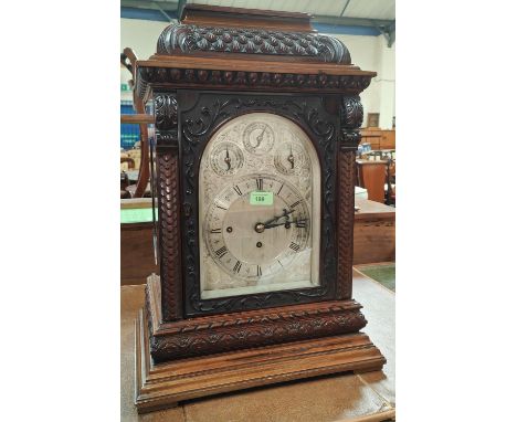 A late 19th century large impressive bracket clock in carved mahogany case with caddy top, chased and arched silvered dial, 8