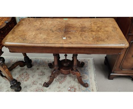 A Victorian burr walnut card table with quarter veneered fold-over top and marquetry decoration, on 4 turned columns and scro