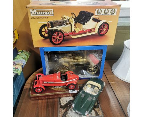 A boxed Mamod steam roller with a Wilesco model and two Burago cars.