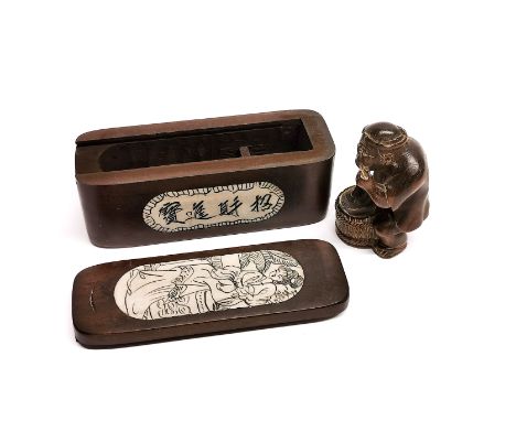 A carved signed fruitwood netsuke with an inlaid oriental box.