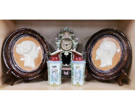 A pair of glazed ceramic portrait plaques, H. 24cm. Together with a ceramic clock and a pair of German porcelain vases.