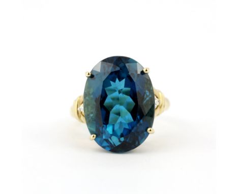 A 9ct yellow gold ring set with a large blue topaz and diamonds, ring size R.5.