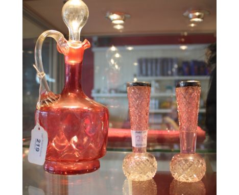 A late Victorian cranberry glass liqueur decanter and stopper, three cranberry frill neck dishes, a pair of silver mounted sp