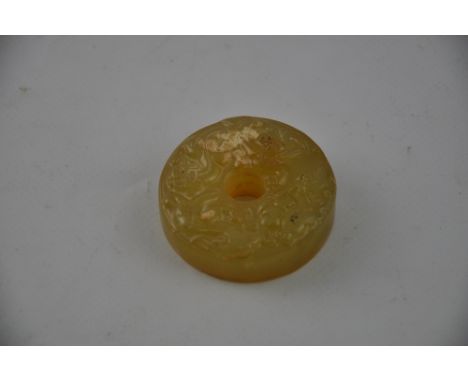 A carved jade disc, depicting mythical beasts, D. 5cm.