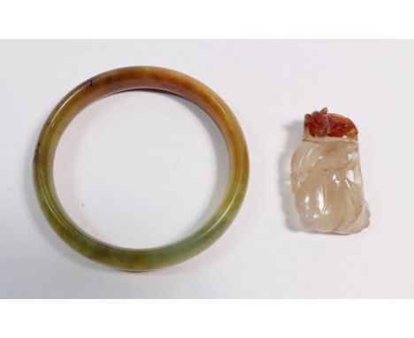 A Chinese jade bangle, 7cm diameter and a jade pendant with carved rat on organic leaf decoration, 4cm