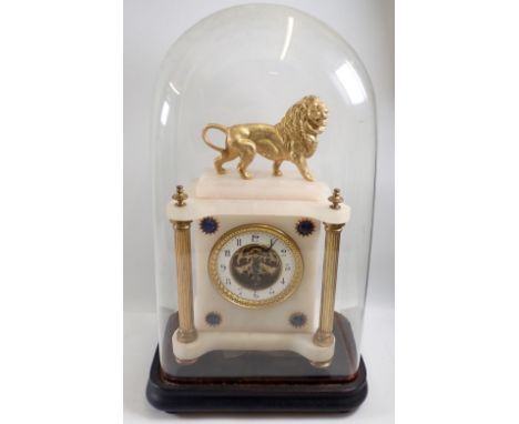 A Victorian alabaster mantel clock with lion surmount, blue ceramic and gilt corner prunts and visible escapement to dial, al