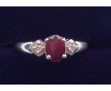 A 9 carat white gold ring set ruby flanked by two diamonds, size O to P, 2.1g