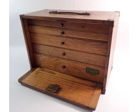 An oak drop front collectors/engineers tools cabinet comprising five drawers and leather handle by Enox with key, 40.5 x 31 x