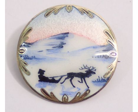 A Norwegian silver and enamel circular brooch decorated reindeer and sled scene, 3.7cm diameter