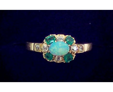 A gold ring set oval opal within emerald and diamond surround, unmarked but thought to be 18 carat, size P, 3.2g