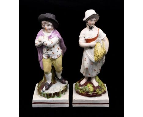 A pair of 19th Century Staffordshire figures modelled as Autumn and Winter: Autumn carries a scythe and bunch of wheat, she w