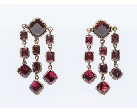 A pair of Georgian garnet and gold drop earrings, each comprising a cushion table cut foil backed set to the top suspending t