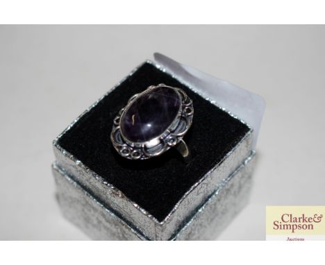 A white metal dress ring set amethyst coloured stone 