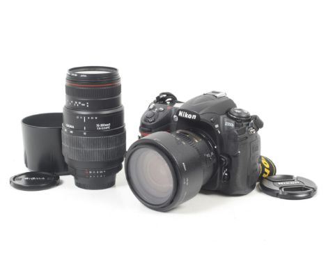 A Nikon D300s Digital SLR camera outfit. With two lenses; a Nikon 18-70mm f3.5-4.5 AF-S Nikkor and a Sigma 70-300mm f4-5.6 Ma
