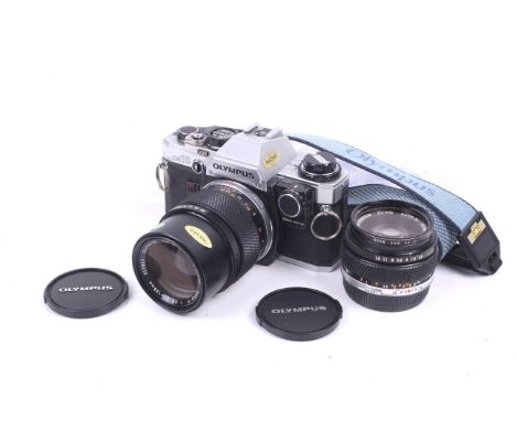 An Olympus OM10 35mm SLR camera outfit. With two lenses; an Olympus 50mm f1.8 Zuiko Auto S, and an Olympus 135mm f3.5 E.Zuiko