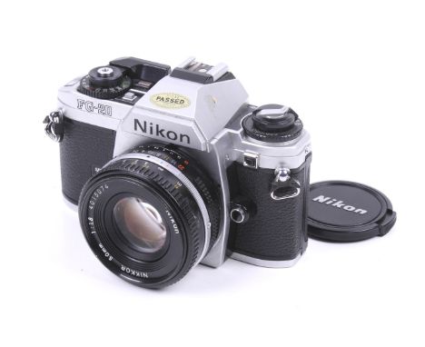 A Nikon FG-20 35mm SLR camera. Chrome. With a Nikon 50mm f1.8 Nikkor lens, lens cap, strap and instruction manual. Shutter wo