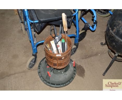 A wicker basket and contents of hand tools and a  Christmas tree stand 