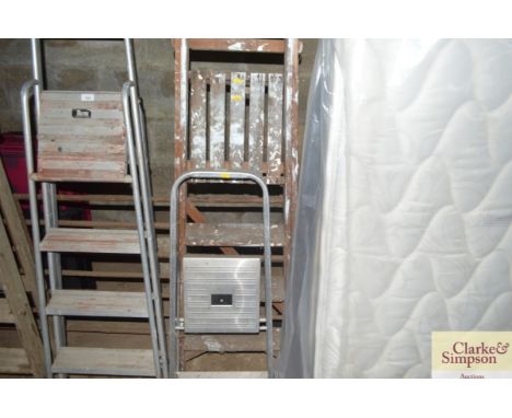 A wooden step ladder and an aluminium set of steps