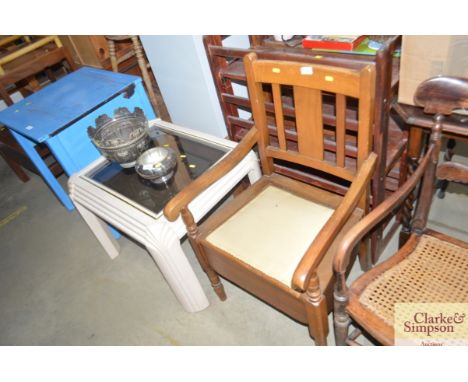 A commode chair and a modern glass topped coffee table