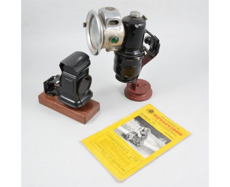 The Revenge an acetylene cycle lamp, another vintage cycle lamp and a Silverstone souvenir programme 1949, (3).