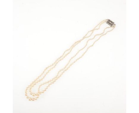 A two row cultured pearl necklace, the pearls graduating from 2.5mm to 6.3mm, knotted every pearl and fitted with a silver fi